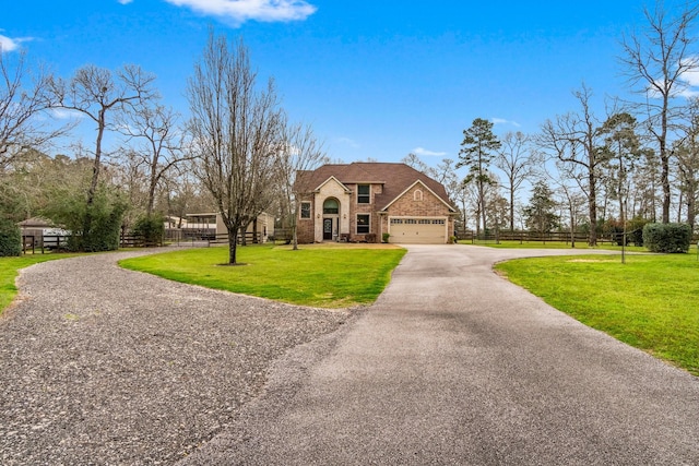 view of front facade with driveway, a garage, fence, a front yard, and brick siding