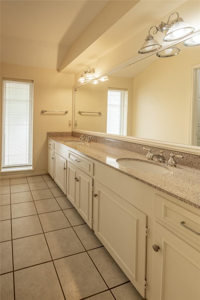 bathroom with tile patterned flooring, a sink, and double vanity