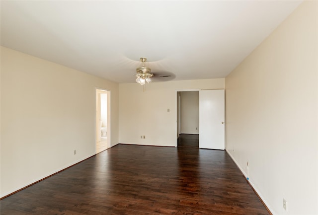 spare room with dark wood-style floors, a ceiling fan, and baseboards