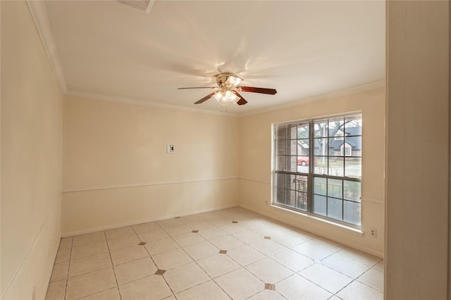 spare room with ceiling fan, baseboards, and crown molding