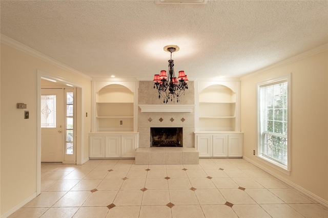 unfurnished living room featuring a notable chandelier, a fireplace, built in features, and a textured ceiling