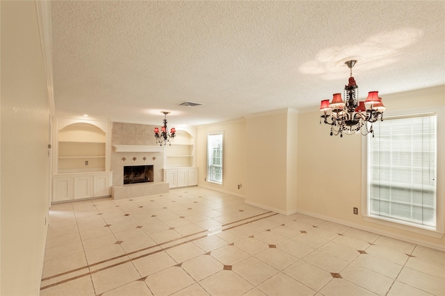 unfurnished living room with built in shelves, a tile fireplace, a notable chandelier, visible vents, and crown molding