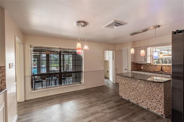 kitchen with visible vents, decorative backsplash, dark wood-style flooring, a healthy amount of sunlight, and a sink