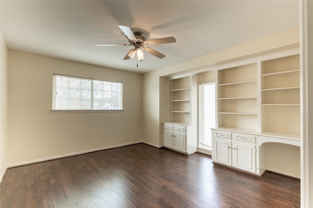 interior space with baseboards, dark wood finished floors, and a ceiling fan