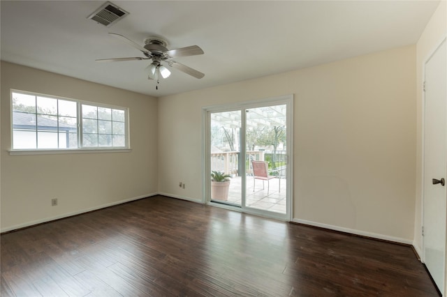 empty room with a healthy amount of sunlight, visible vents, and wood finished floors