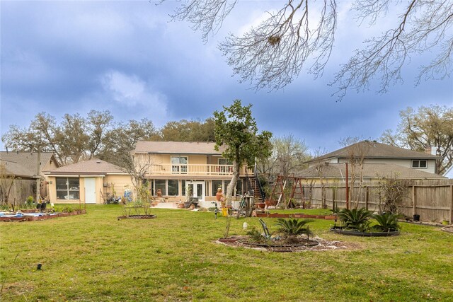 rear view of house with fence, a yard, stairway, a wooden deck, and a patio area