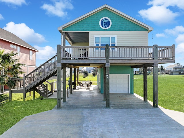 coastal inspired home with stairs, driveway, a front lawn, and a garage