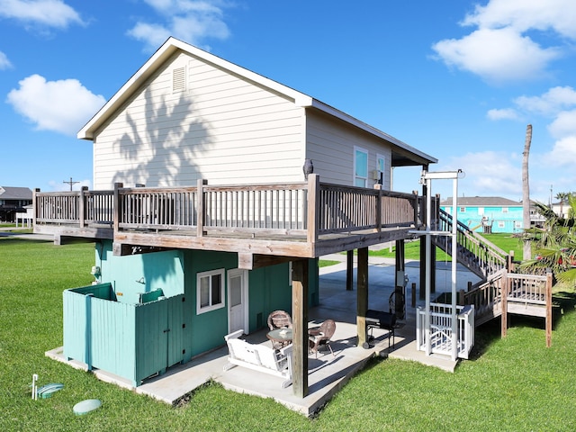 rear view of property with a wooden deck, stairway, a lawn, and a patio