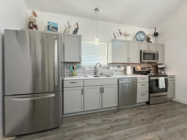 kitchen with tasteful backsplash, appliances with stainless steel finishes, a sink, and gray cabinetry