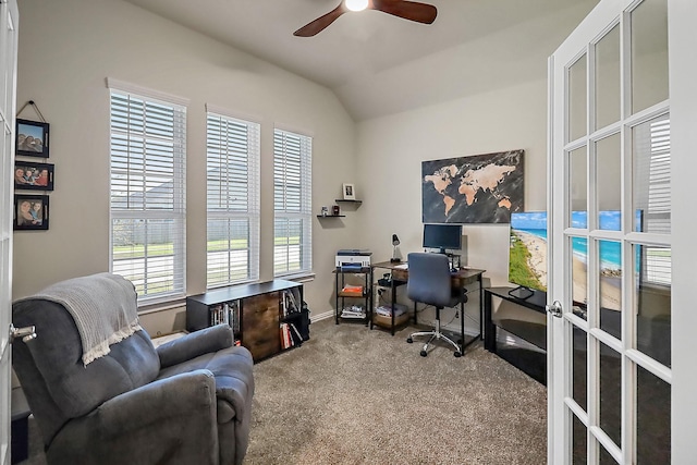 carpeted office space featuring vaulted ceiling, a ceiling fan, and french doors