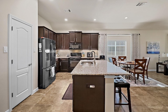 kitchen featuring visible vents, a sink, backsplash, and black appliances