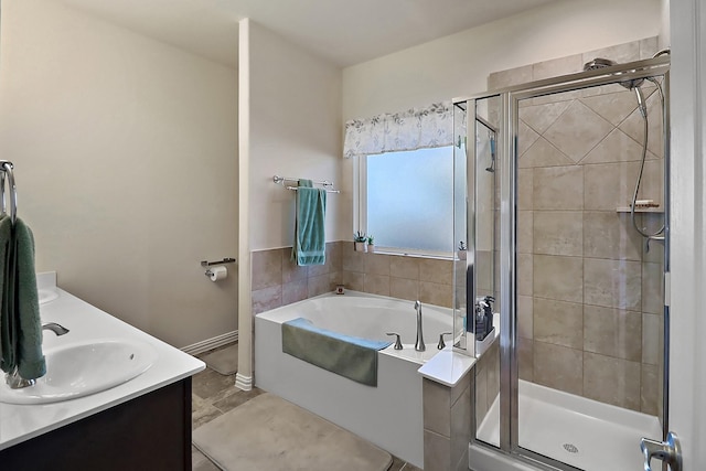 bathroom with a sink, baseboards, a shower stall, a bath, and double vanity