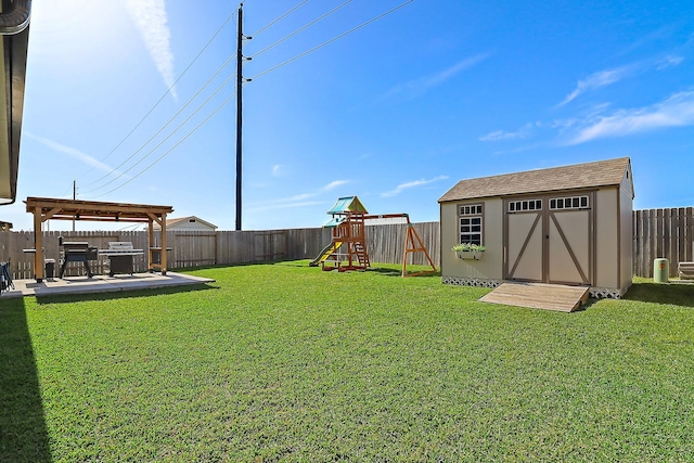 view of yard featuring a fenced backyard, a shed, a playground, and an outdoor structure