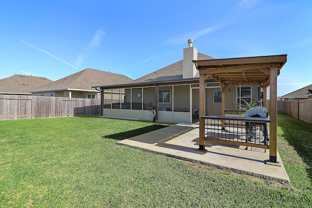 back of property featuring a fenced backyard, a sunroom, a lawn, a chimney, and a patio area