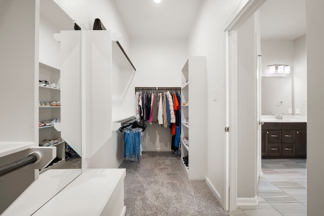 spacious closet featuring light carpet and a sink