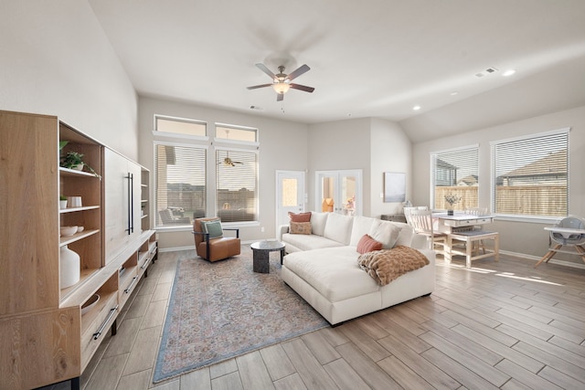 living room with a wealth of natural light, wood finish floors, vaulted ceiling, and baseboards