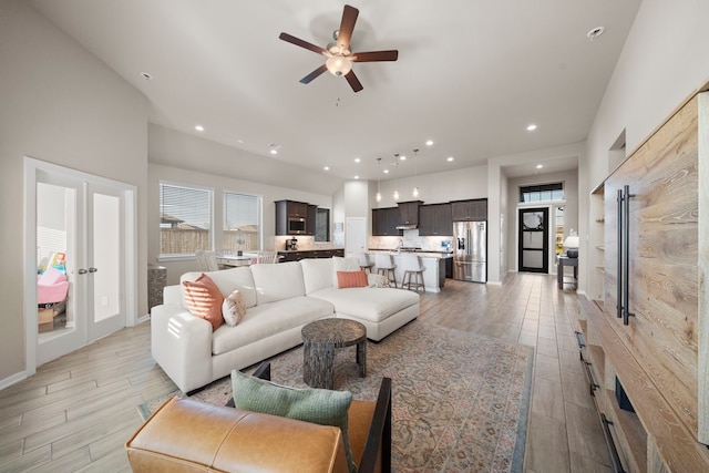 living area featuring light wood-type flooring, ceiling fan, and recessed lighting