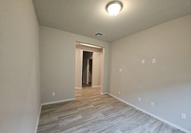 spare room featuring baseboards and visible vents