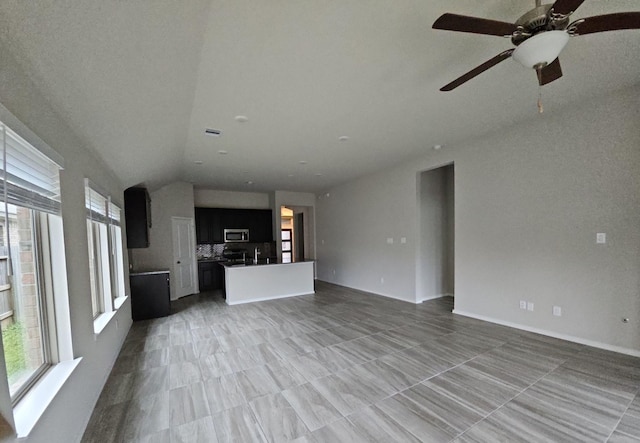 unfurnished living room featuring vaulted ceiling and a sink