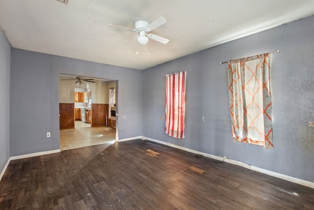 unfurnished room with a ceiling fan, baseboards, and wood finished floors