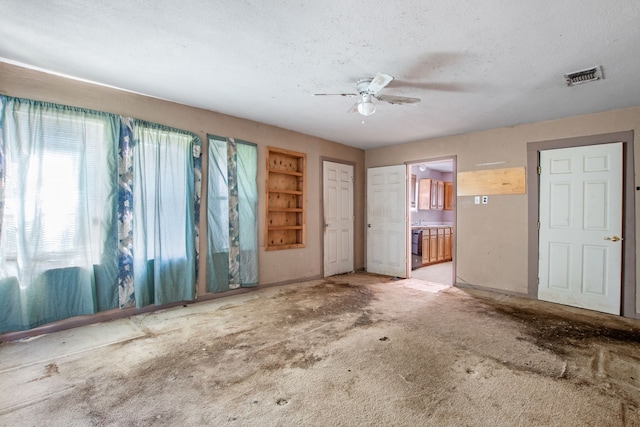 spare room with a ceiling fan, visible vents, and a textured ceiling