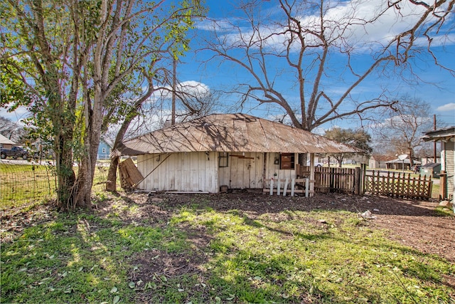 back of property with fence and an outdoor structure