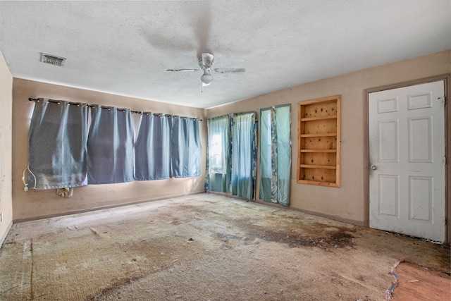 empty room featuring visible vents, ceiling fan, and a textured ceiling