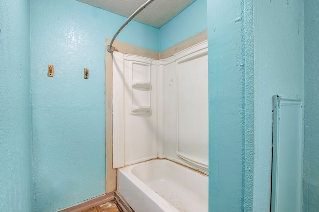 full bath with a textured wall and shower / washtub combination