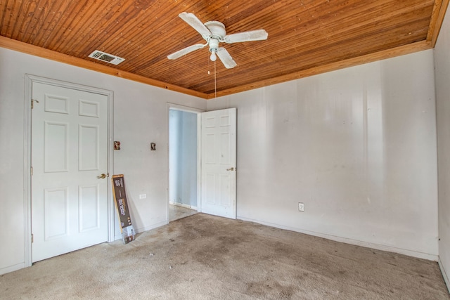 spare room featuring visible vents, carpet flooring, wood ceiling, and a ceiling fan