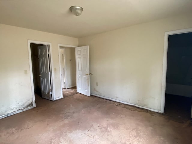 unfurnished bedroom with unfinished concrete flooring