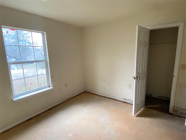 unfurnished bedroom with multiple windows and a closet