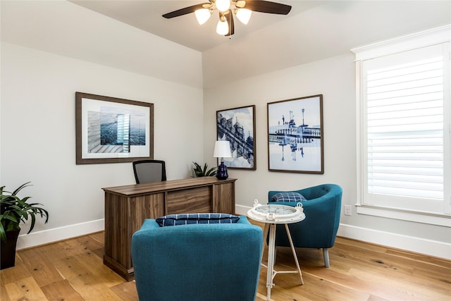 home office with light wood-style floors, baseboards, and a ceiling fan