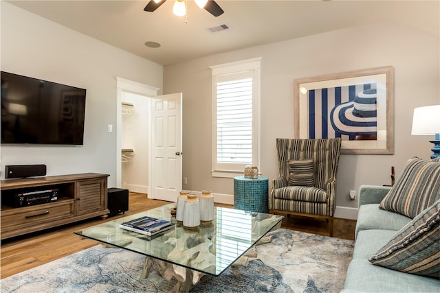 living area featuring ceiling fan, wood finished floors, visible vents, and baseboards