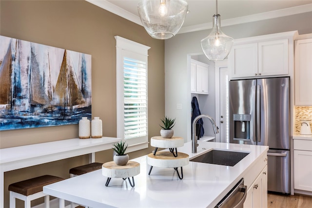 kitchen featuring tasteful backsplash, appliances with stainless steel finishes, a sink, and crown molding