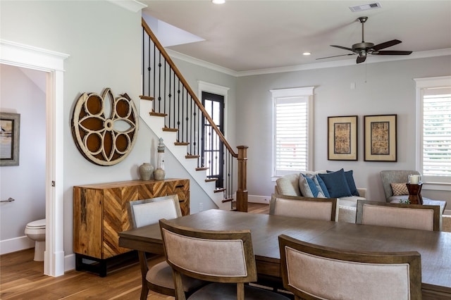 dining room featuring a wealth of natural light, stairs, and crown molding