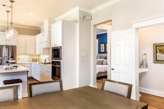 kitchen with stainless steel appliances, dark wood-type flooring, a sink, white cabinets, and backsplash