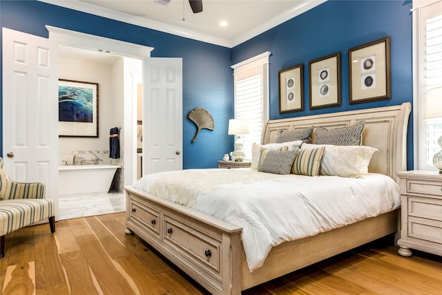 bedroom featuring ornamental molding, wood finished floors, and ensuite bathroom