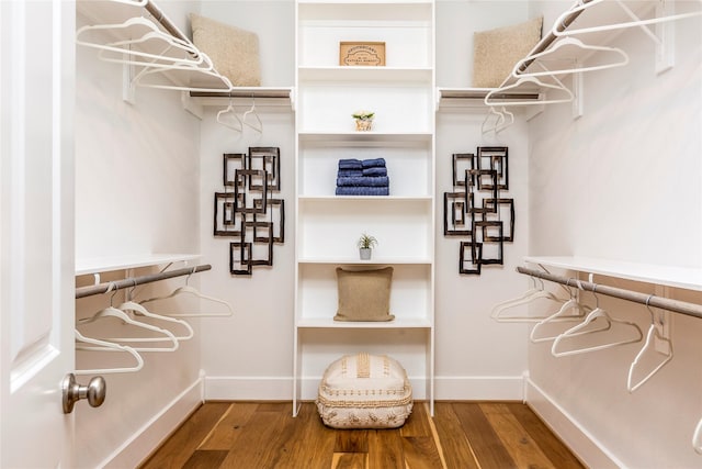 walk in closet with wood finished floors