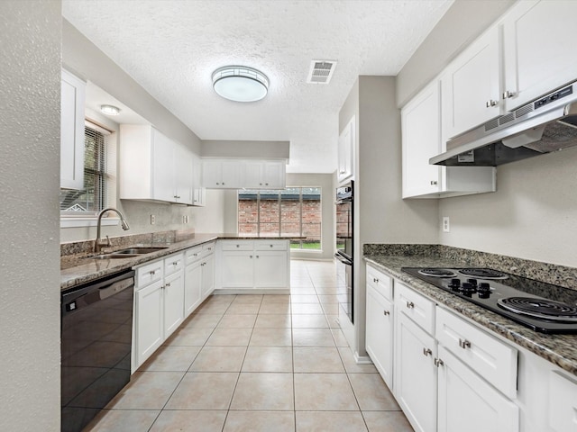 kitchen featuring visible vents, under cabinet range hood, white cabinets, black appliances, and a sink