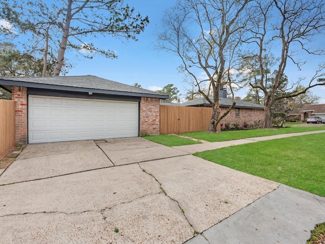 garage featuring fence and driveway