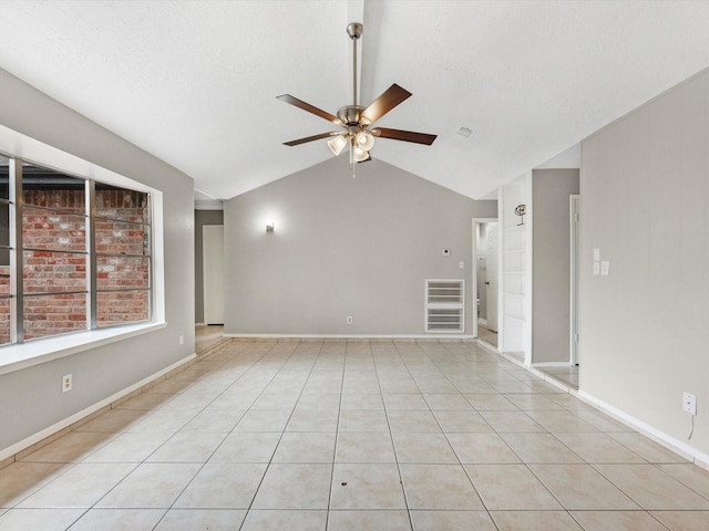 spare room with light tile patterned floors, lofted ceiling, a textured ceiling, and ceiling fan