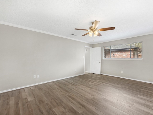 spare room featuring visible vents, a textured ceiling, wood finished floors, and ornamental molding