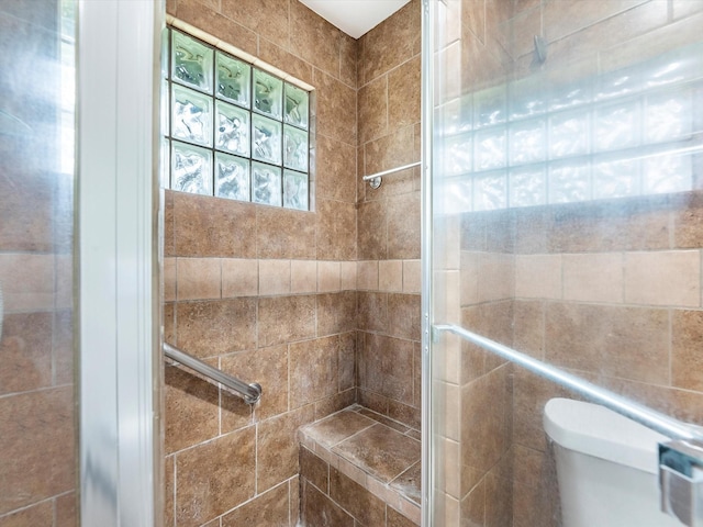 full bath featuring a shower stall and toilet