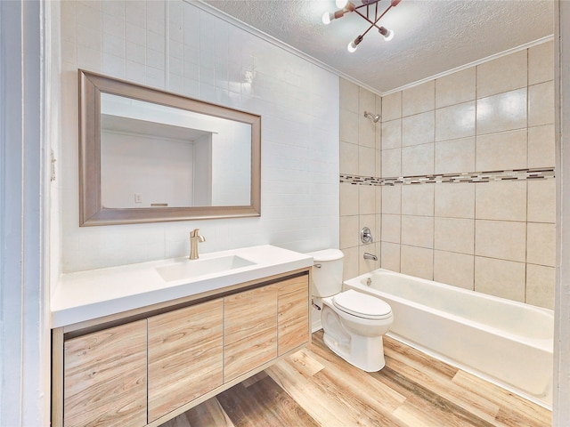 full bath with a textured ceiling, toilet, wood finished floors, vanity, and  shower combination