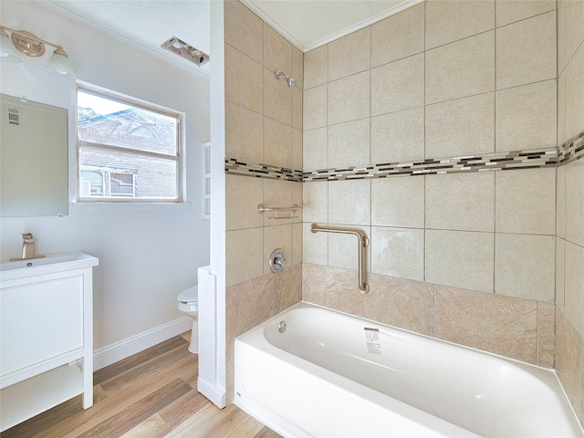 full bath with bathing tub / shower combination, toilet, vanity, wood finished floors, and baseboards