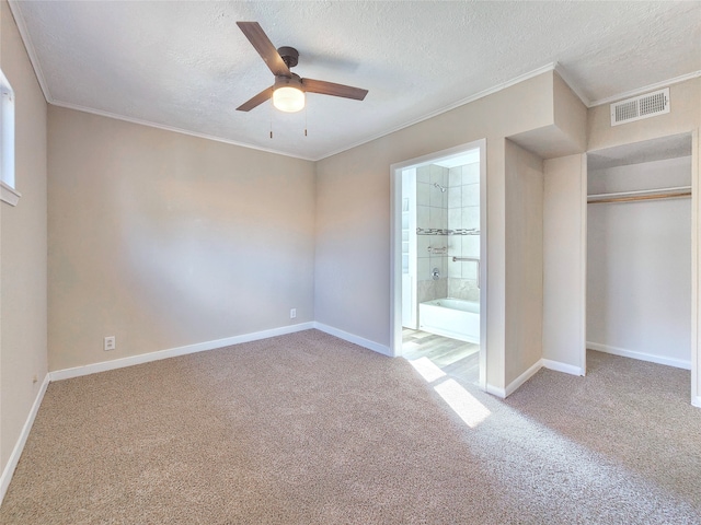 unfurnished bedroom featuring carpet, visible vents, crown molding, and baseboards