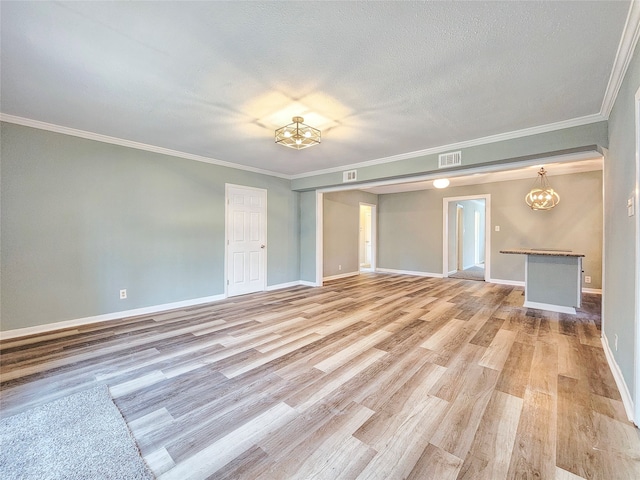 interior space with light wood-type flooring, visible vents, a textured ceiling, and baseboards