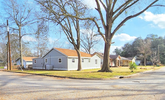 view of side of home featuring a yard and a residential view