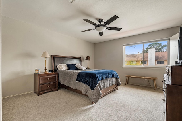 bedroom with a ceiling fan, light colored carpet, and baseboards