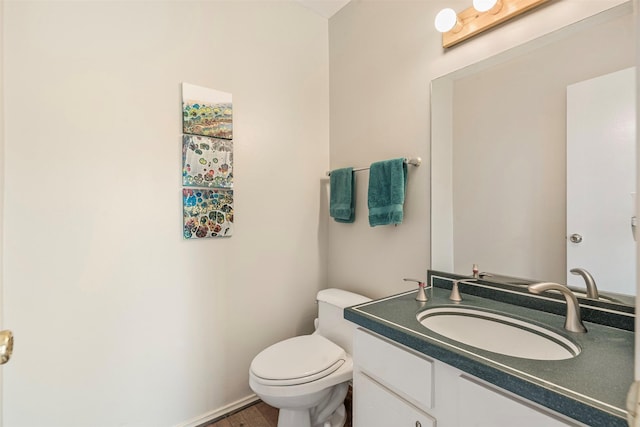 bathroom with toilet, baseboards, and vanity